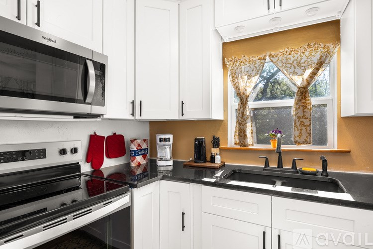 A kitchen with white cabinets and a black stove top.