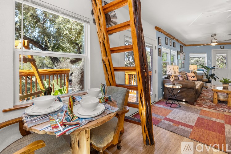 A wooden table with plates and utensils on it in a room with a ladder.