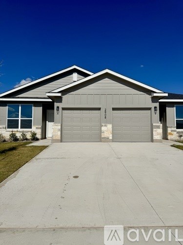 A two-car garage with a concrete driveway in front.
