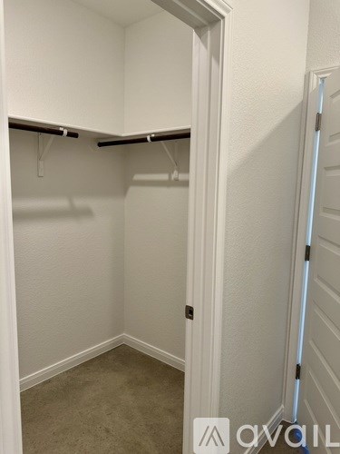 A small white closet with a door and a shelf.