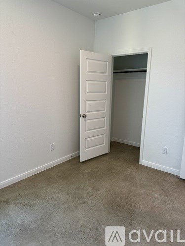 A room with a white door and carpeted floor.
