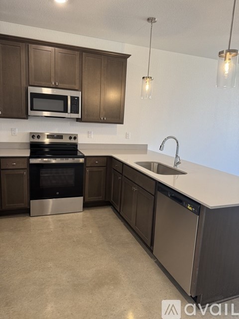 A kitchen with brown cabinets and stainless steel appliances.