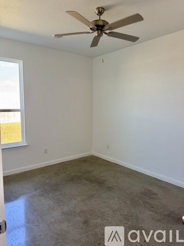 A room with a ceiling fan and a window.