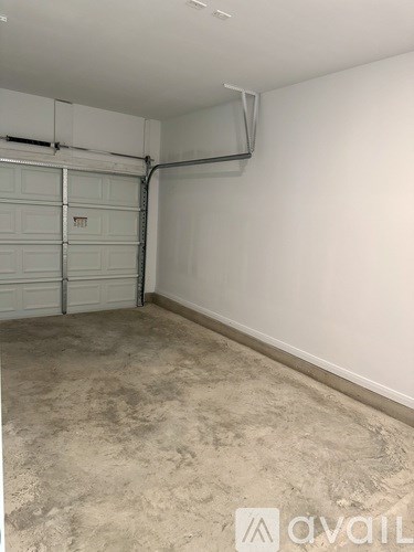 A garage with a white wall and a closed white door.