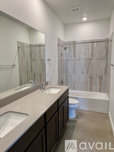 A bathroom with a white toilet and a bathtub with a shower curtain.
