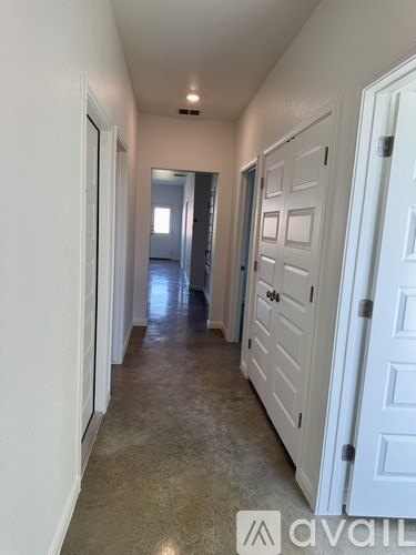 A long hallway with white doors on both sides.