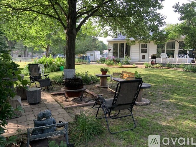 A backyard with a fire pit and chairs.