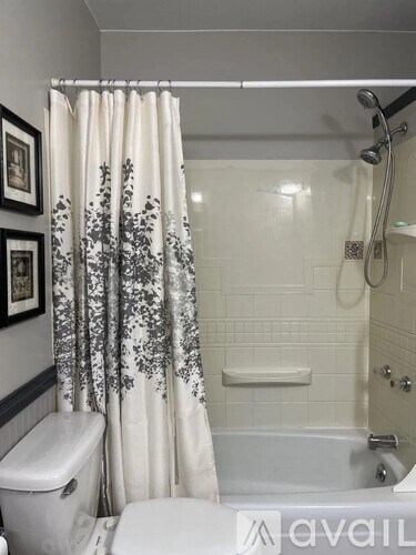 A white toilet sits next to a bathtub in a bathroom.
