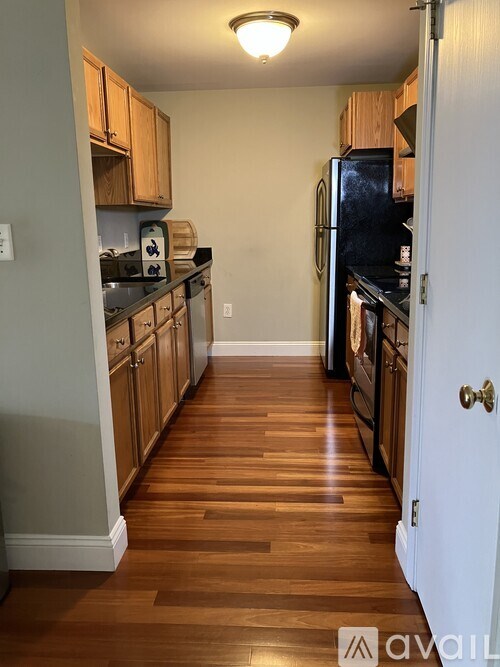A kitchen with wooden floors and a white door.