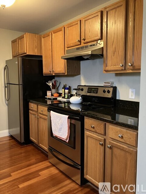 A kitchen with wooden cabinets and black appliances.