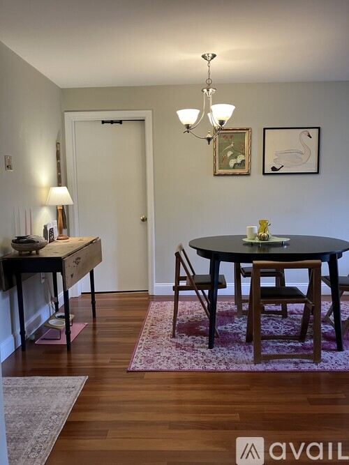 A dining room with a round table and chairs.