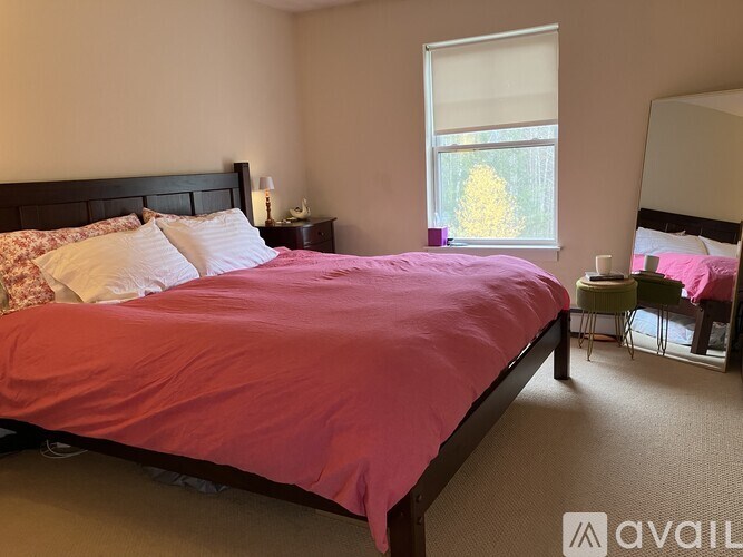 A bedroom with a large bed and a window.