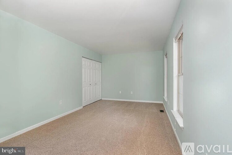 A room with a carpeted floor and a white door.