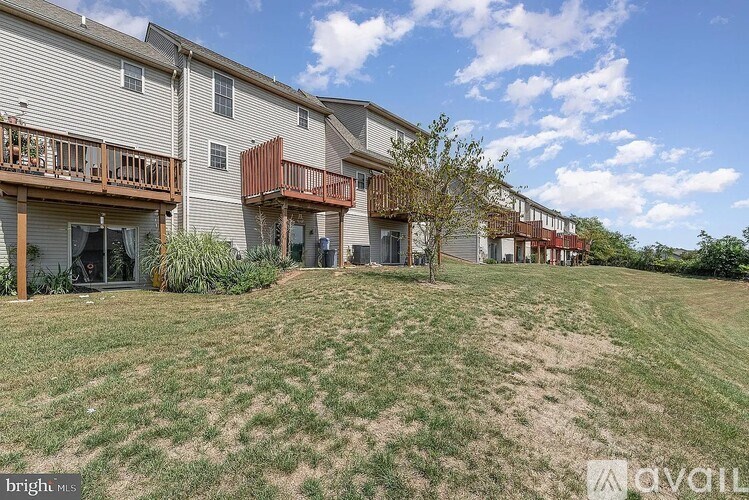 A row of houses with balconies and a grassy area in front.