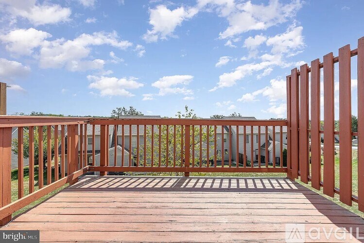A wooden deck with a red fence and a clear blue sky.