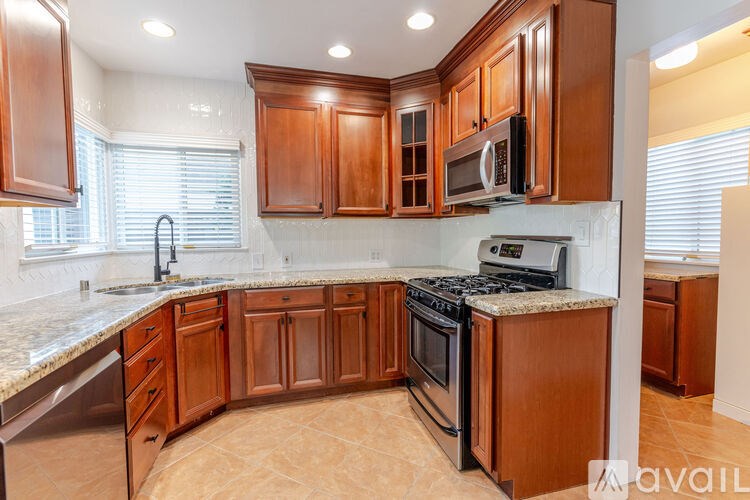 A kitchen with wooden cabinets and a marble countertop.
