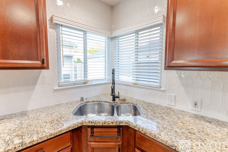 A kitchen with a granite countertop and wooden cabinets.