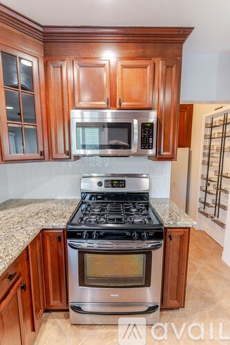 A kitchen with wooden cabinets and a stove top oven.