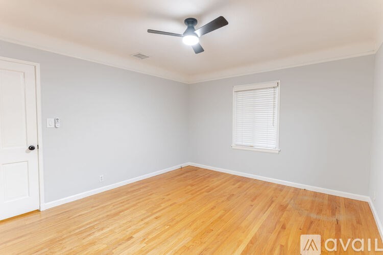 A room with wooden flooring and a ceiling fan.