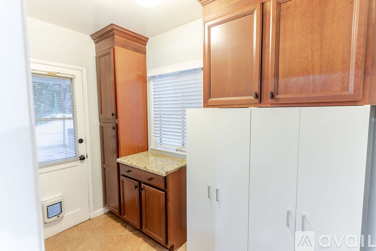 A kitchen with wooden cabinets and a granite countertop.
