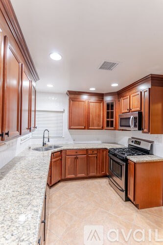 A kitchen with wooden cabinets and a granite countertop.