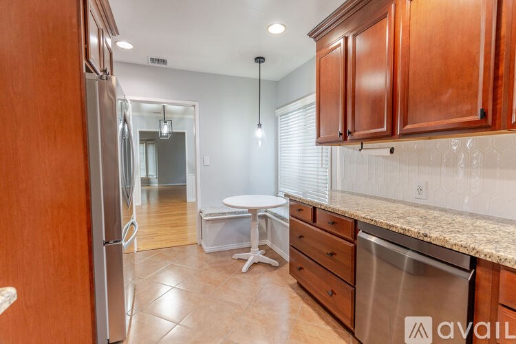 A kitchen with wooden cabinets and a stainless steel dishwasher.