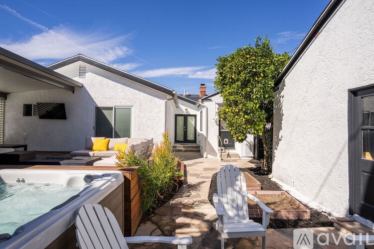 A sunny day at a backyard with a hot tub and chairs.