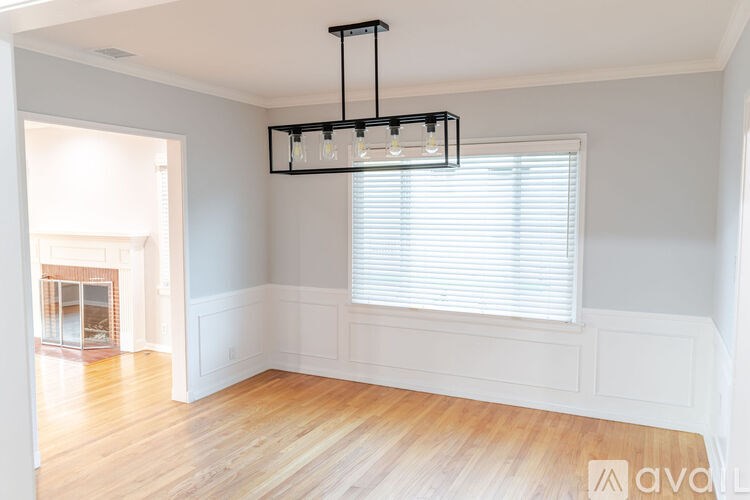 A room with wooden floors and a chandelier hanging from the ceiling.