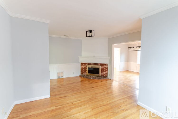 A room with a fireplace and wood flooring.