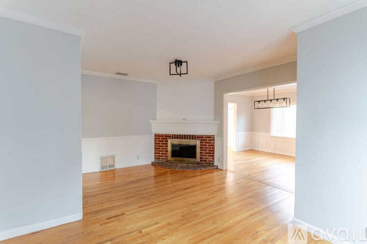 A room with a fireplace and wooden floors.