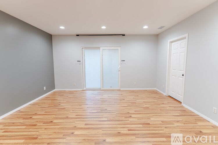 A room with wooden flooring and white walls.
