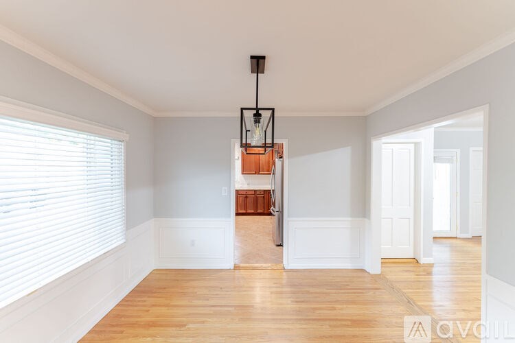 A room with wooden floors and a chandelier hanging from the ceiling.