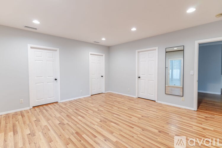A room with wooden flooring and white walls.