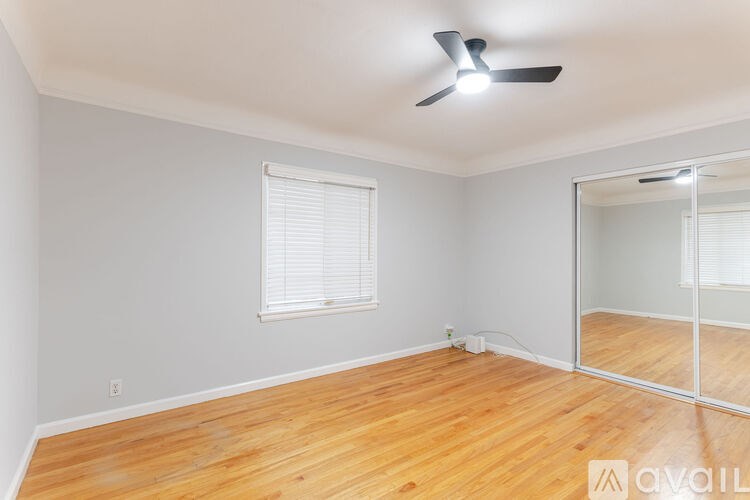 A room with wooden floors and a ceiling fan.