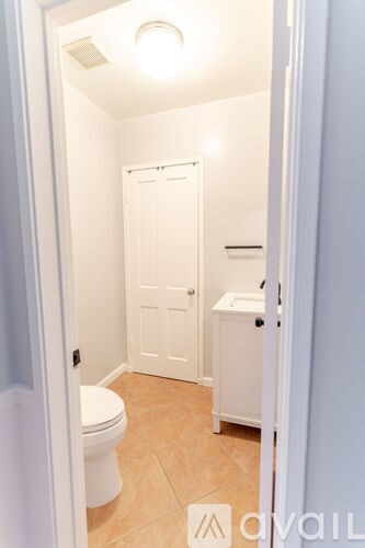 A small bathroom with a toilet, sink and shower.