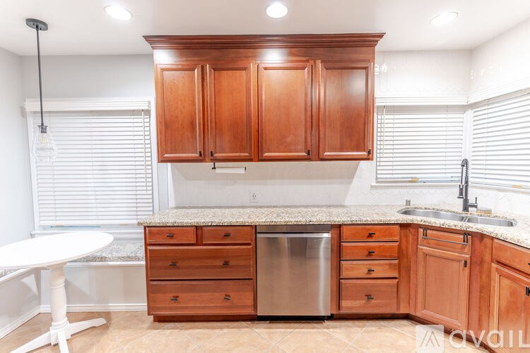 A kitchen with wooden cabinets and a granite countertop.