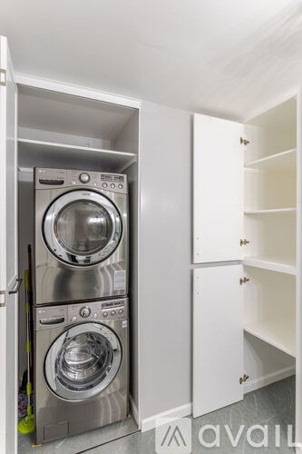 A washing machine is built into a wall in a laundry room.