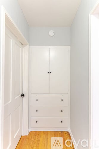 A white closet with drawers and a door.