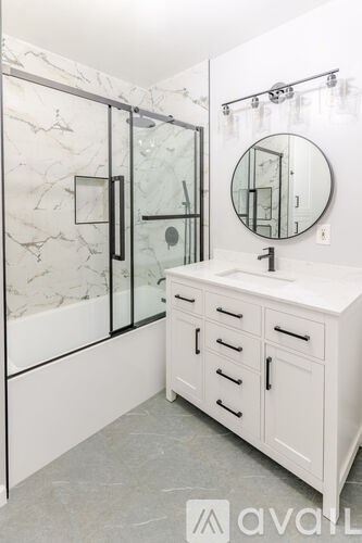 A bathroom with a marble wall and a white vanity.