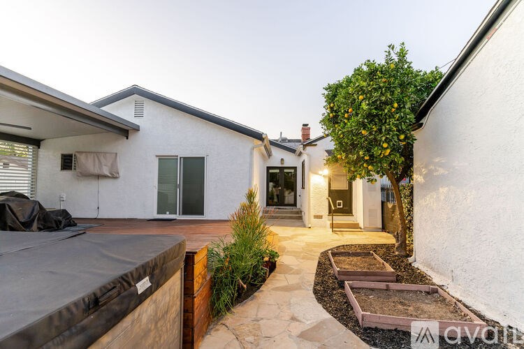 A white house with a trampoline in the yard.