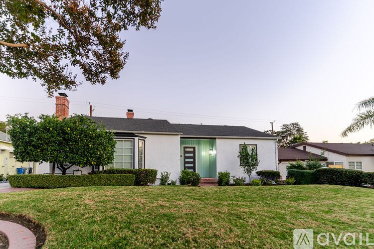 A house with a green door and a tree in front.