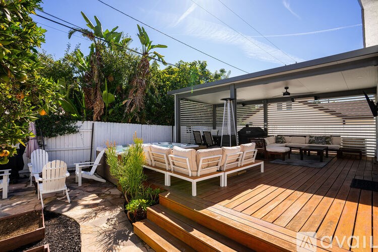 A patio with white furniture and a wooden deck.