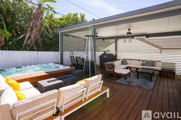 A wooden deck with a hot tub and seating area.