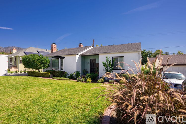 A white house with a green lawn in front.