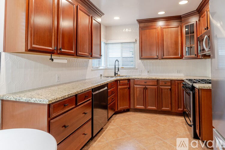 A kitchen with wooden cabinets and a granite countertop.