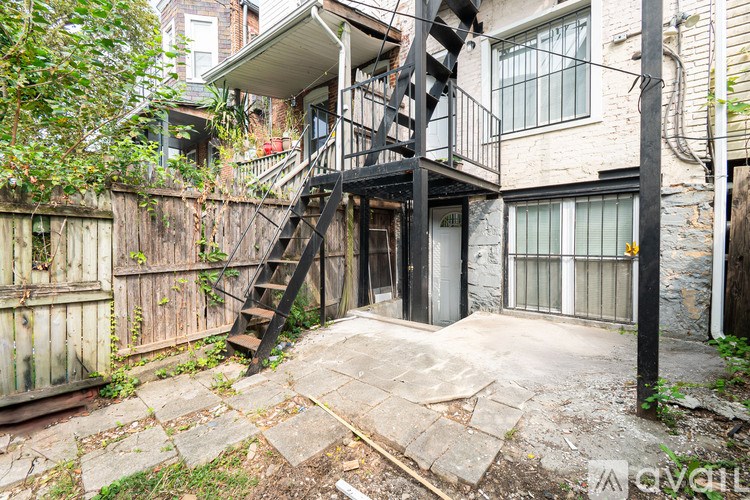 A backyard with a wooden fence and a black metal staircase.
