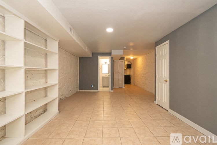 A long hallway with a white door at the end.