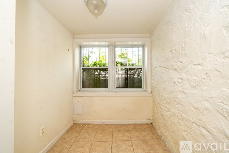 A room with a window and a ceiling light.