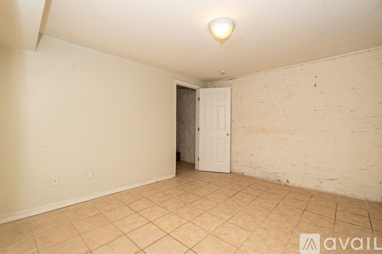 A room with a white door and tiled floor.