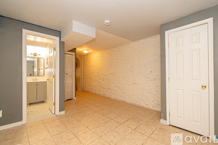 A room with a white door and a wall with a stone pattern.